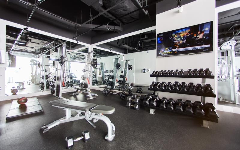 a room with a large screen and weights